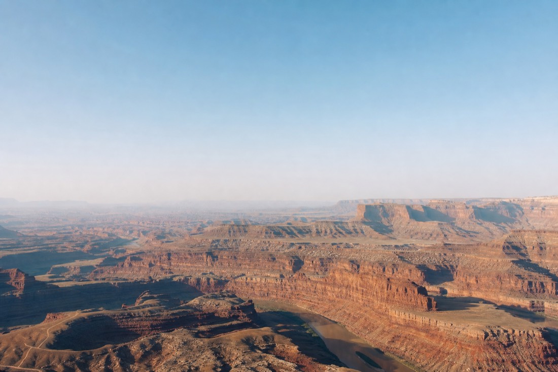 The canyon seen from above with vast empty airspace over the layered gorge at midday