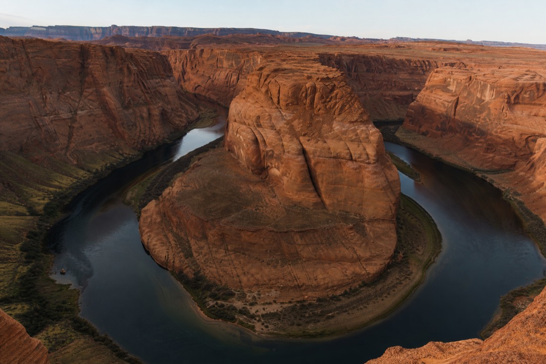 The Colorado River wrapping around the sandstone curve of Horseshoe Bend under afternoon light near Page Arizona