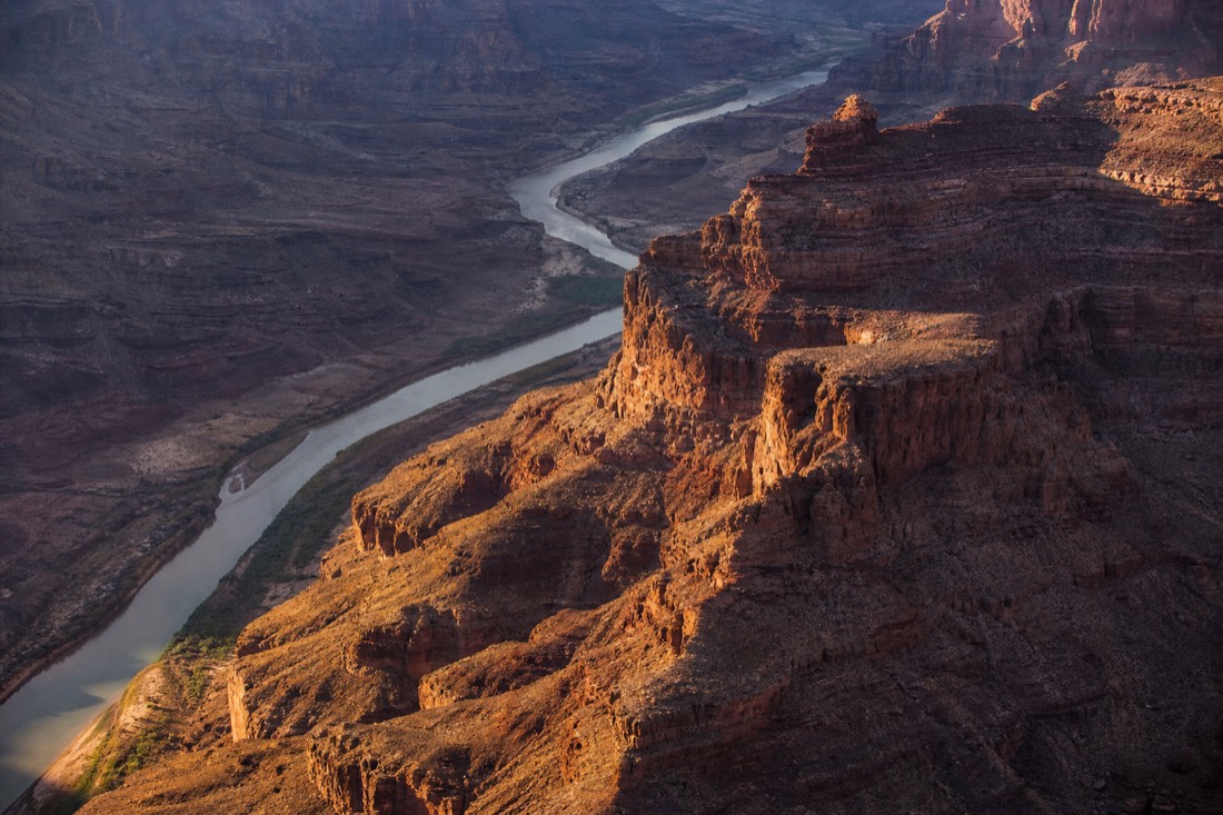 The Grand Canyon seen from the air with the Colorado River threading between layered rock walls