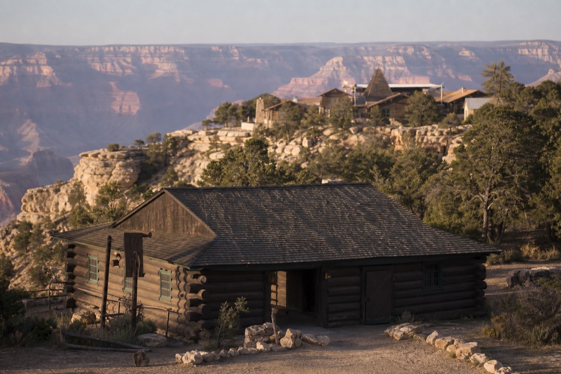 The historic 1910 log depot at Grand Canyon Village with the rim-side historic district rising behind it
