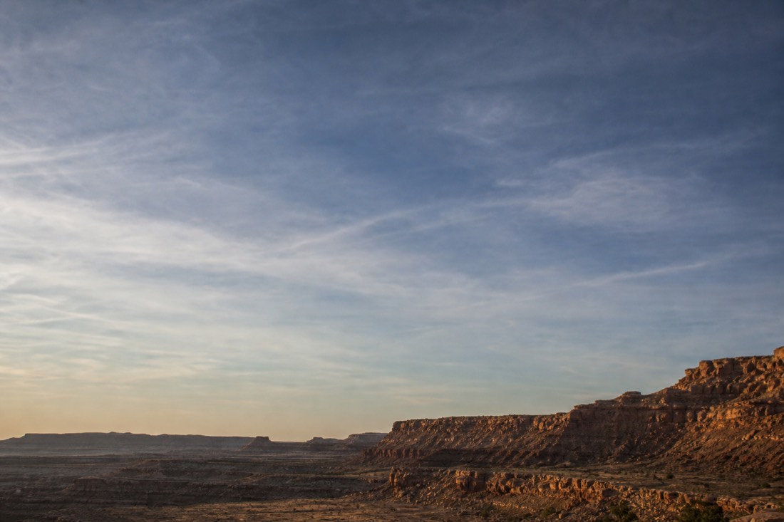 An empty expanse of high desert sky over the plateau with thin cloud and no aircraft in sight