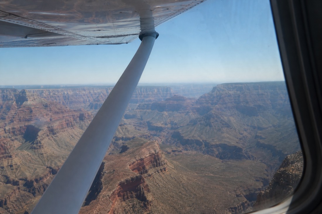 The wing of a small sightseeing airplane over the wide eastern Grand Canyon on a clear day