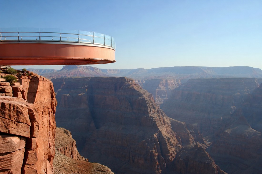 The Grand Canyon Skywalk glass bridge extending over the canyon edge at Grand Canyon West under a hot clear sky