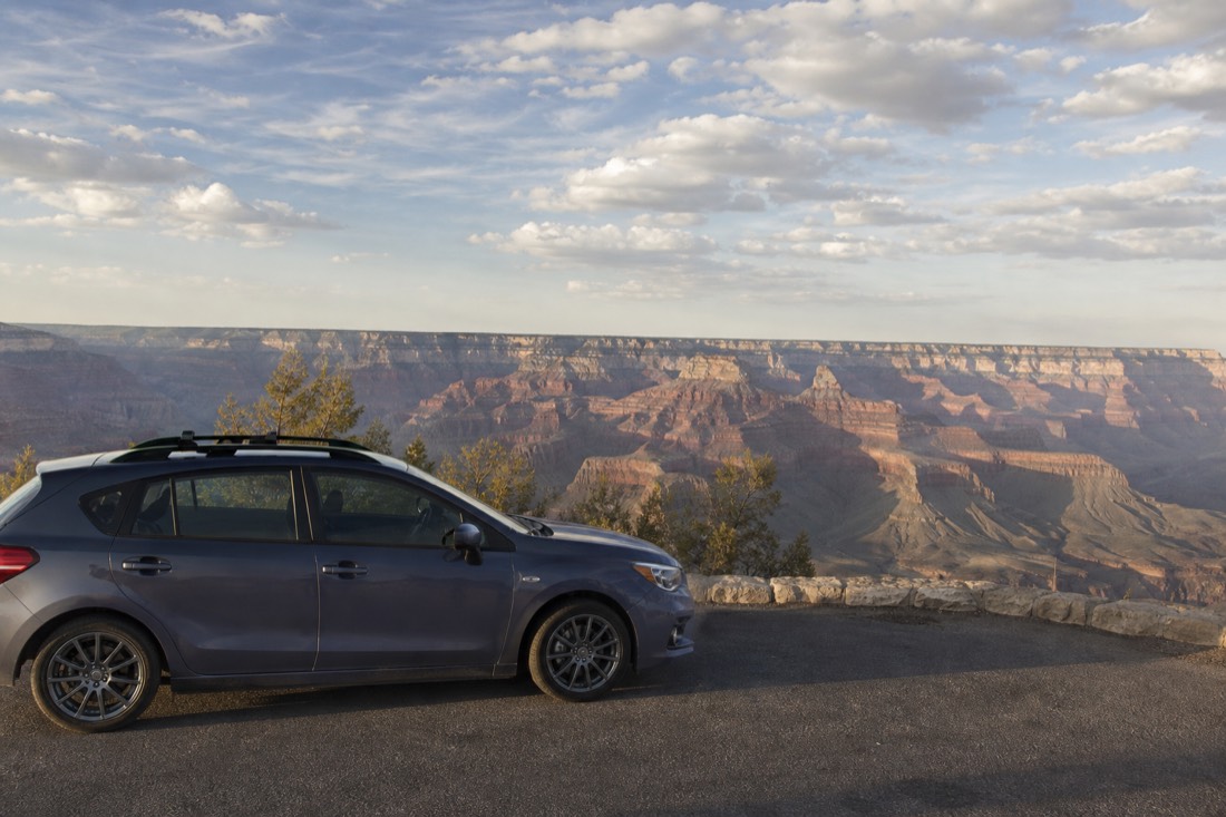A car parked at a South Rim overlook in the afternoon with the canyon stretching to the horizon