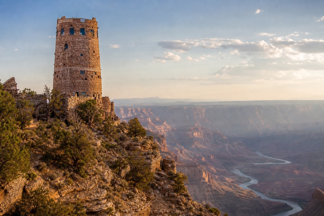 Stone Desert View Watchtower standing on the canyon edge in warm late light with the river bending far below