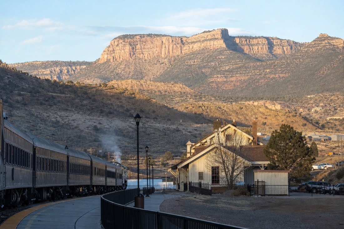 Vintage passenger train waiting at the Williams depot on a clear morning with passengers boarding